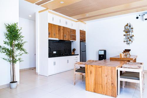 a kitchen with white cabinets and a wooden table at La Boutique villas Seminyak Bali in Seminyak