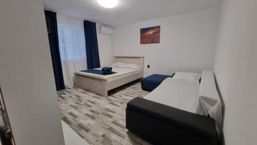 a small bedroom with two beds and a couch at Casa Bianca in Eforie Nord