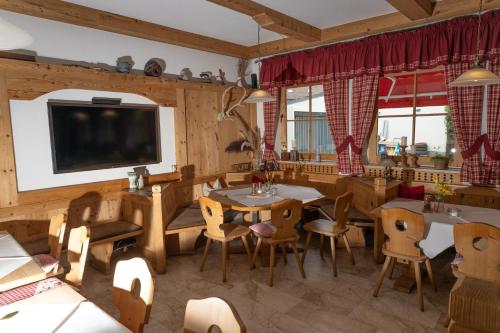 a dining room with a tv and tables and chairs at isarwinkel in Geretsried