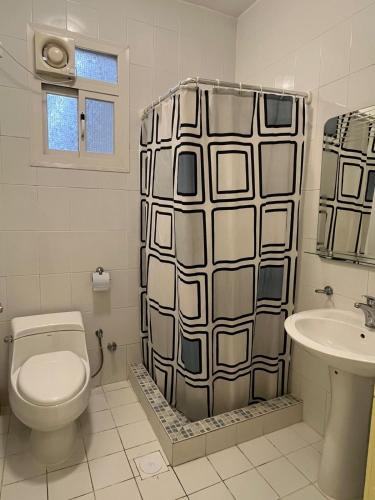 a bathroom with a toilet and a shower curtain at فندق قوافل الشام in Tabuk