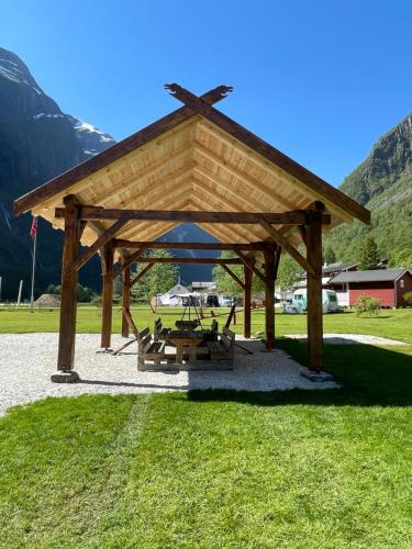 a wooden pavilion with a picnic table in a field at Gudvangen Camping in Gudvangen