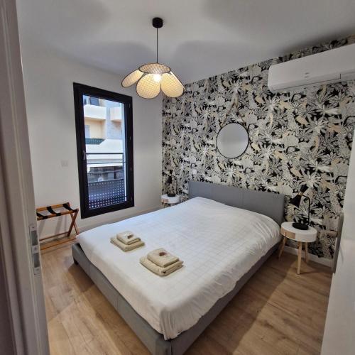 - une chambre avec un lit blanc et un mur noir et blanc dans l'établissement Villa Provençale, à Sète