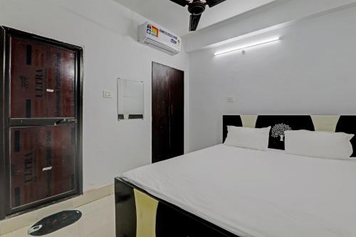 OYO Hotel R Glory في باتنا: غرفة نوم مع سرير أبيض كبير في غرفة