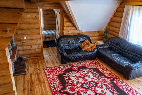 a living room with two leather chairs and a rug at Lambievi Kolibi in Gorno Kraishte