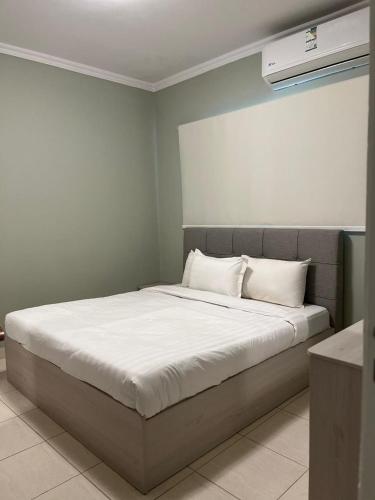 a bed with white sheets and pillows in a room at فندق قوافل الشام in Tabuk