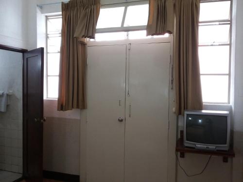 a bathroom with a white door and a tv at Hotel Centenario in Guatemala