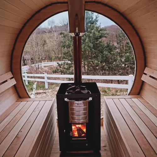a wood stove in a room with a window at Siedlisko Panorama na Koncu Swiata - Całoroczny domek in Podgórz