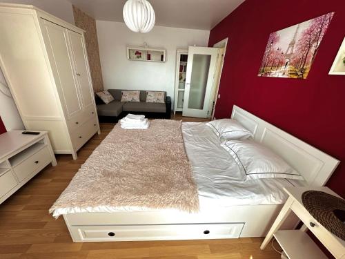 1 dormitorio con cama blanca y pared roja en Le Petit Paris- Central , Dorobanți with a view en Bucarest