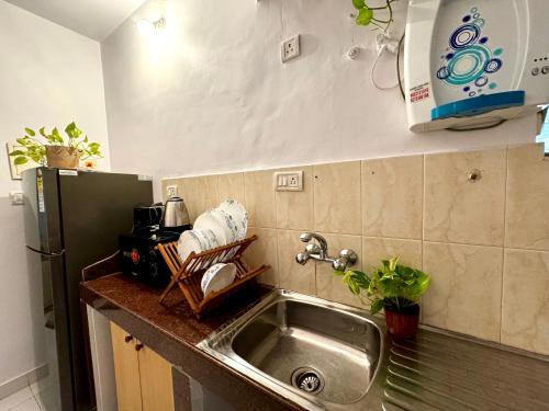um balcão de cozinha com um lavatório e um frigorífico em LUSO Beach Homes Goa em Benaulim