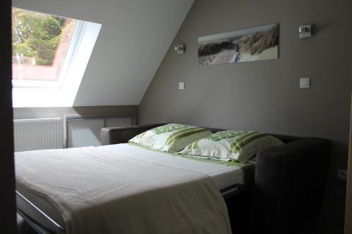 Ce lit se trouve dans une petite chambre dotée d'une fenêtre. dans l'établissement La Tonnelle, à Hardelot-Plage