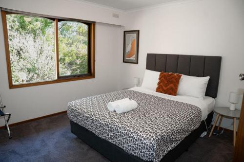 a bedroom with a bed and a window at Port Bayou House in Port Campbell
