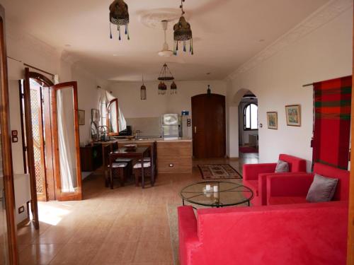 sala de estar con sofá rojo y mesa en Villa Quiet Place, en Luxor