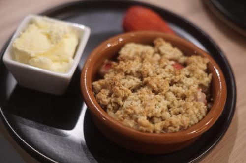 a plate with a bowl of food and a bowl of butter at Les Cocons d AleXan Le Chalet balnéo aromathérapie in Quinssaines