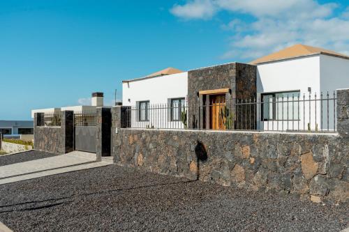 un muro di pietra di fronte a una casa di Seascape Piscina climatizada aire acondicionado a Corralejo