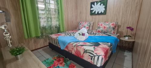 a bedroom with a bed with a stuffed animal on it at Tauraatini House F4 - PAPEETE in Papeete