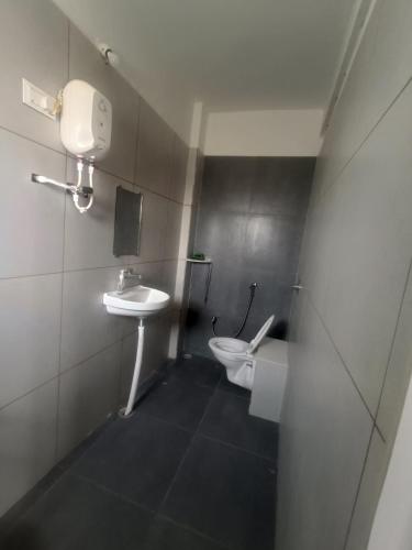 a small bathroom with a toilet and a sink at Matoshree Guesthouse in Akalkot