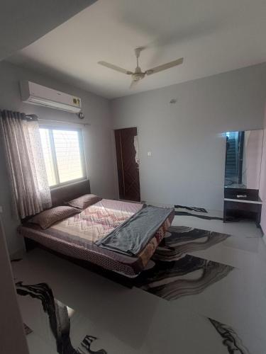 a bed in a room with a ceiling fan at Matoshree Guesthouse in Akalkot