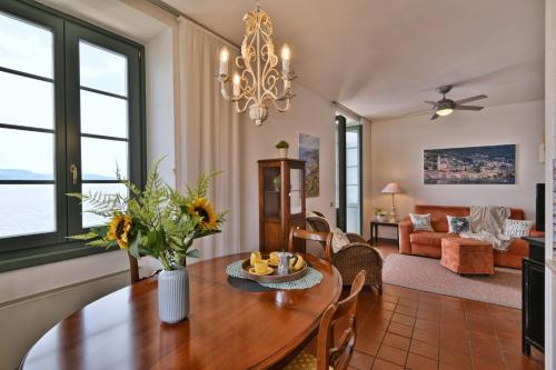 a dining room and living room with a table and chairs at Appartamento Panorama al Porto - Theater Home in Gargnano