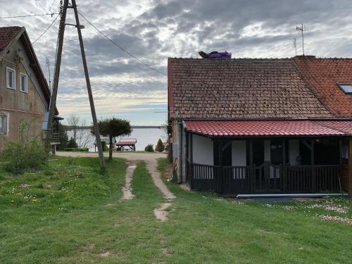 a house with a bench on the roof of it at Pokoje nad jeziorem Dobskim półwysep Fuleda in Fuleda