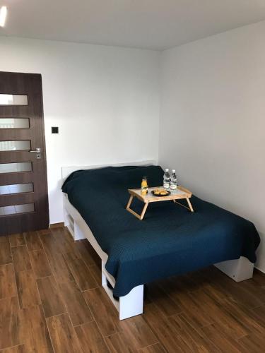 a bedroom with a bed with a table on it at Pokoje nad jeziorem Dobskim półwysep Fuleda in Fuleda