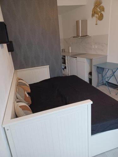 Ce lit blanc se trouve dans un dortoir doté d'une cuisine. dans l'établissement Studio calme avec un lit, à Bordeaux