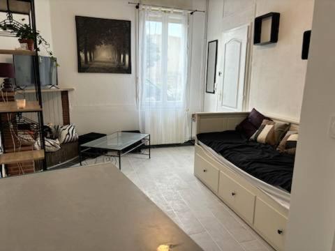 un salon avec un lit et une table dans l'établissement Studio calme avec un lit, à Bordeaux