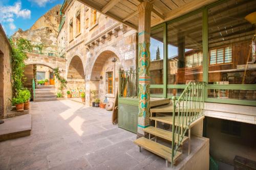an old building with a staircase in a courtyard at Terra Cave Hotel in Goreme