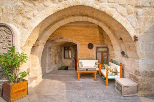 a stone archway with two chairs and a table at Terra Cave Hotel in Göreme