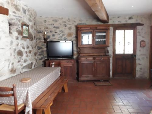 - un salon avec une télévision et un banc en bois dans l'établissement LA Boulzane, à Puilaurens