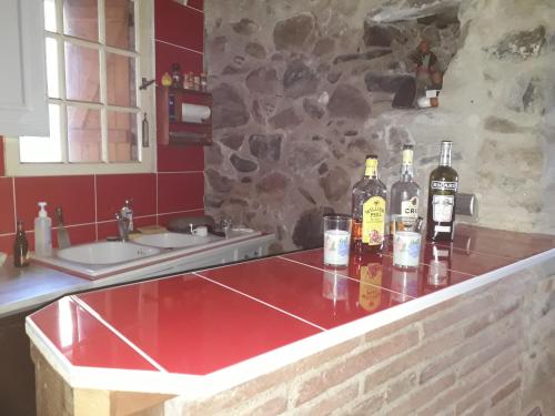 - une cuisine avec un comptoir avec des bouteilles de vin et des verres dans l'établissement LA Boulzane, à Puilaurens