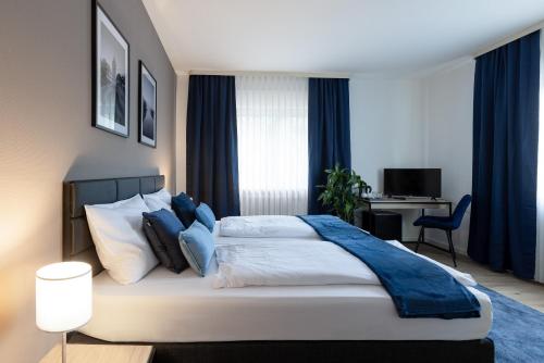 a bedroom with a large bed with blue accents at Hotel Wegener in Mannheim