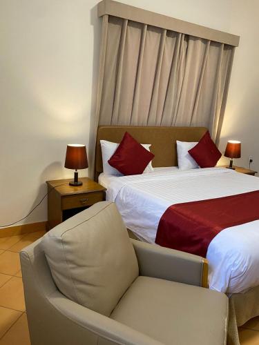 a hotel room with two beds and a chair at فندق قوافل الشام in Tabuk
