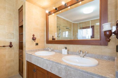 a bathroom with two sinks and a large mirror at Villa Son Ferriol in Palma de Mallorca