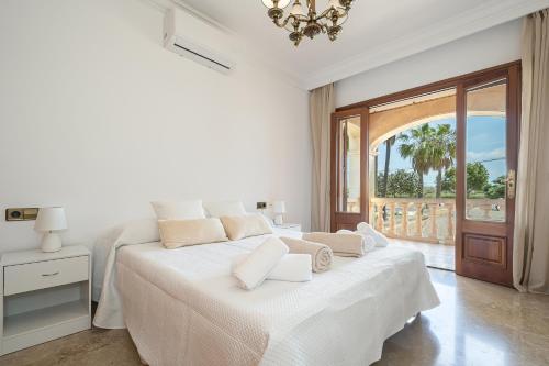 a white bedroom with a large bed and a balcony at Villa Son Ferriol in Palma de Mallorca