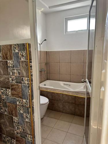 a bathroom with a tub and a toilet and a sink at CazaTara - Modern Villa with Pool in Alaminos in Alaminos