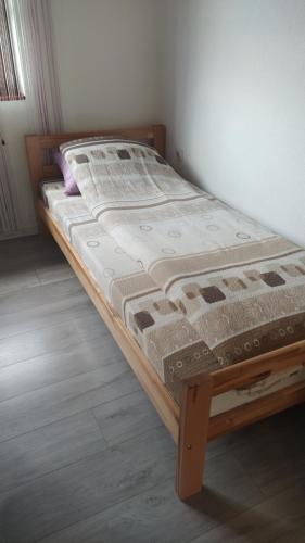Ce lit se trouve dans un dortoir doté d'un cadre en bois. dans l'établissement Medif apartments, à Visoko