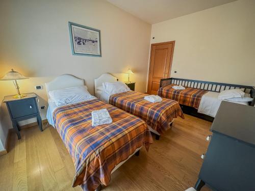 a hotel room with two beds and a table at Casa Paolina in Lucca