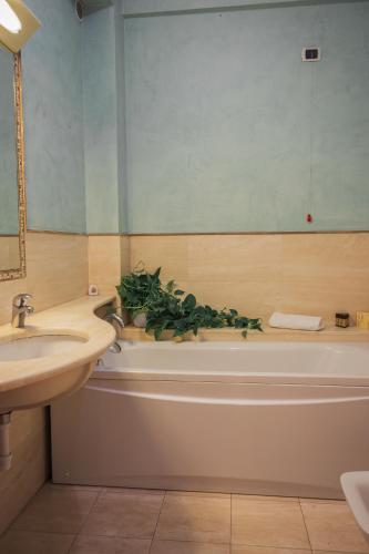 a bathroom with a sink and a tub with plants on it at Casa Paolina in Lucca