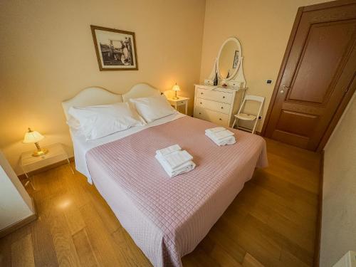 ein Schlafzimmer mit einem Bett mit zwei Handtüchern darauf in der Unterkunft Casa Paolina in Lucca