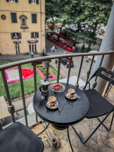 a table with two cups of coffee on a balcony at Casa Paolina in Lucca