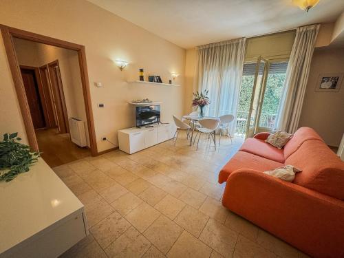 sala de estar con sofá naranja y mesa en Casa Paolina, en Lucca