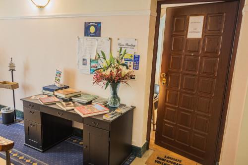 a desk with a vase of flowers on it next to a door at Casa Paolina in Lucca