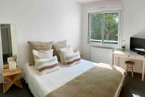 une chambre avec un lit, un bureau et une télévision dans l'établissement La Dune - 6p Arcachon center, terrasse 10m2, à Arcachon