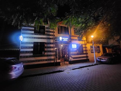 a building at night with a car parked in front at Karma caffe&rooms in Bucharest