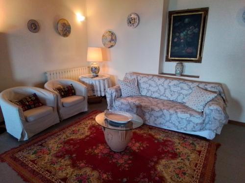 芬奇的住宿－Poderino La Noce，客厅配有沙发和两把椅子
