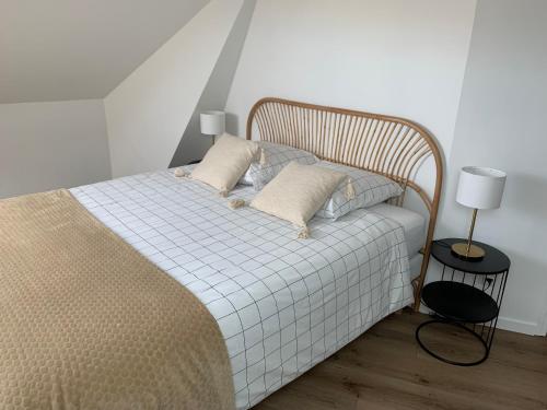 a bed with two pillows on it in a room at Chez Aline & Seb in Boulogne-sur-Mer