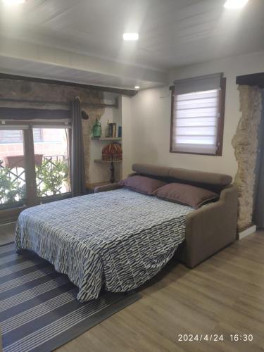 1 dormitorio con 1 cama grande en una habitación con ventanas en CA L'ENGRÀCIA en Tarrés
