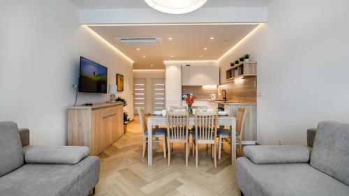 eine Küche und ein Wohnzimmer mit einem Tisch und Stühlen in der Unterkunft Comfy Apartments - Rodzinny Nadmorski Dwór I 10 minut plaża in Danzig