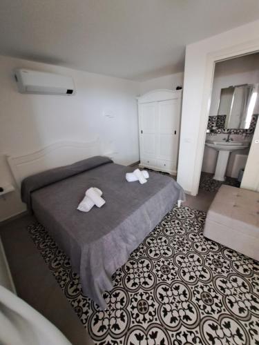 una camera da letto con un letto e due asciugamani di B&B Pepe Rosa Tropea a Tropea