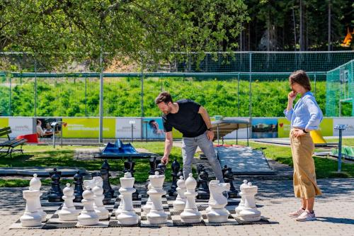 a man and woman playing chess in a park at AHORN Hotel Am Fichtelberg in Kurort Oberwiesenthal